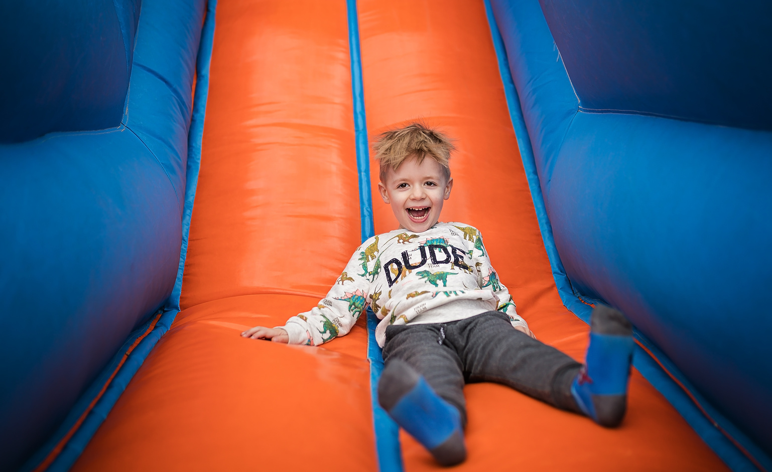 Boy sliding down on a bouncy castle